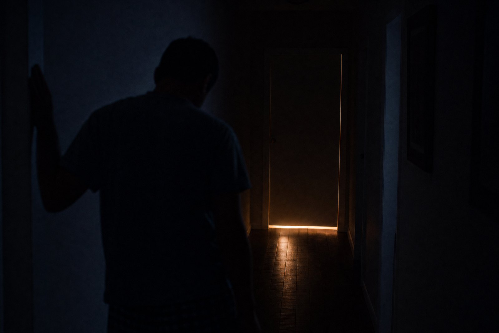 Corridoio buio di notte con la luce del bagno accesa: i risvegli notturni causati dalla prostata